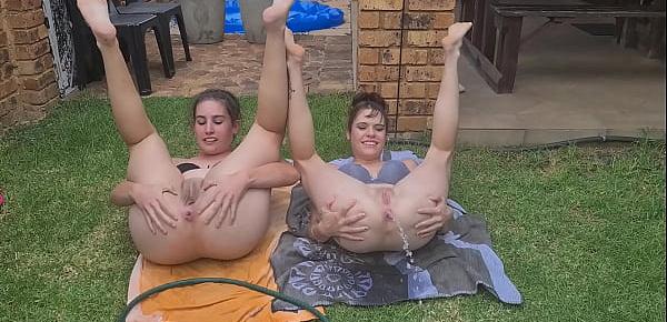  Half naked girls playing with a garden hose